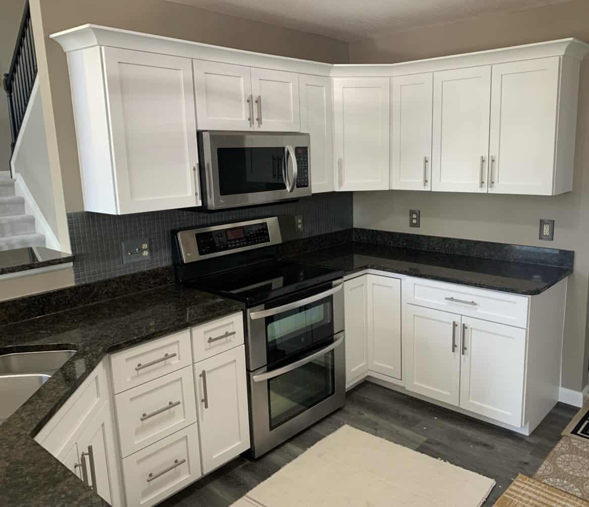 Fully renovated kitchen with brand new white cabinet doors, crown molding, and new hardware.